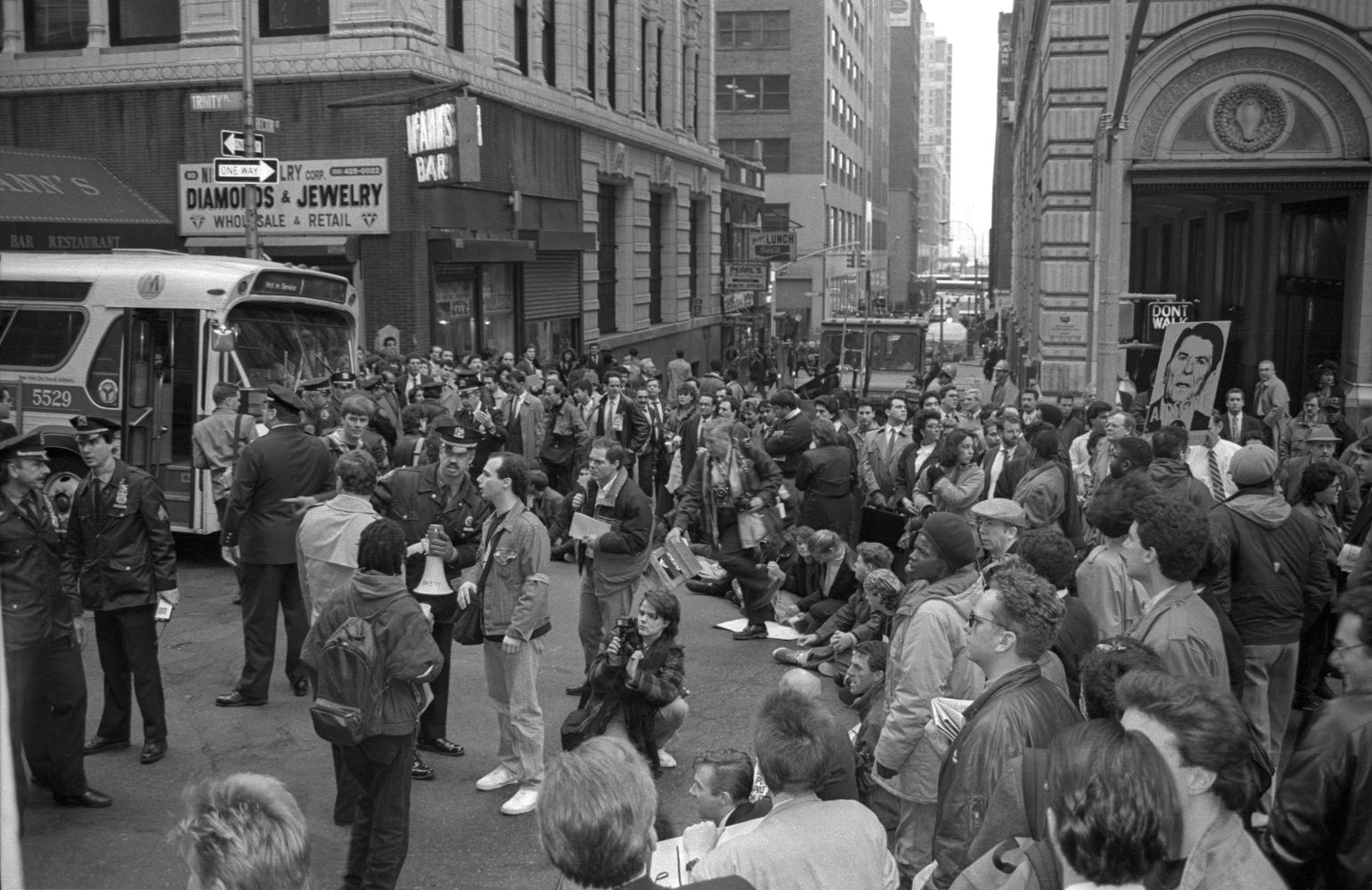 Black and white photo of protestors blocking New York City intersection. A bus is being prevented from proceeding.